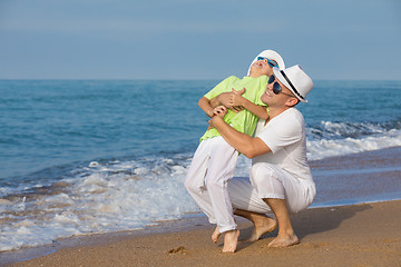 Image showing Father and son playing on the beach at the day time. Concept of 