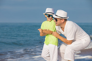 Image showing Father and son playing on the beach at the day time. Concept of 