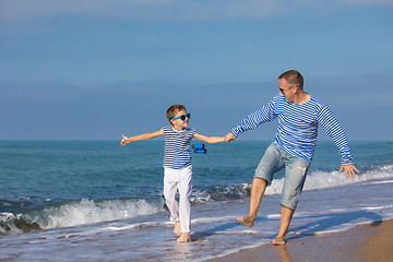 Image showing Father and son playing on the beach at the day time. Concept of 