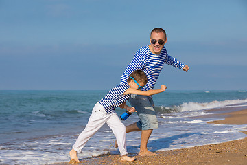 Image showing Father and son playing on the beach at the day time. Concept of 