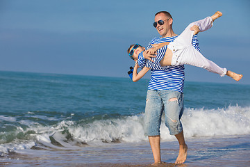 Image showing Father and son playing on the beach at the day time. Concept of 