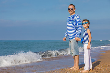 Image showing Father and son playing on the beach at the day time. Concept of 