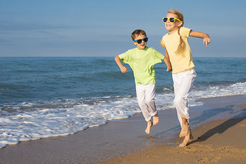 Image showing Two happy children playing on the beach at the day time