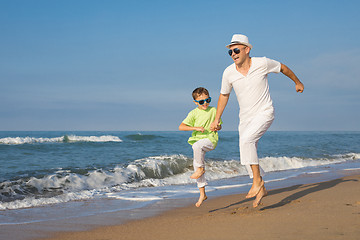 Image showing Father and son playing on the beach at the day time. Concept of 