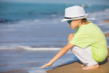 Image showing One happy little boy playing on the beach at the day time