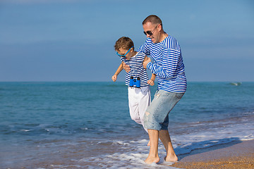 Image showing Father and son playing on the beach at the day time. Concept of 