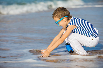 Image showing One happy little boy playing on the beach at the day time