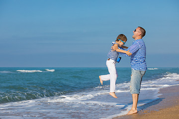 Image showing Father and son playing on the beach at the day time. Concept of 