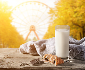 Image showing Milk with a croissant on a wooden table