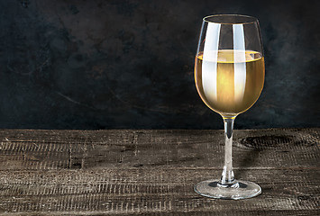 Image showing Glass of white wine on a wooden table