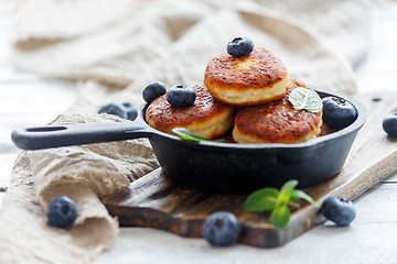 Image showing Cheese pancakes and blueberries in cast iron pan.