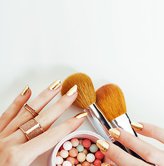 Image showing woman hands with golden manicure  many rings holding brushes, make up artist stuff stylish and pure