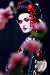 Image showing young pretty real geisha in kimono with sakura and decoration, oriental style fashion