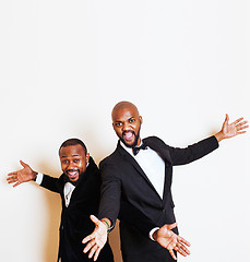 Image showing two afro-american businessmen in black suits emotional posing, gesturing, smiling. wearing bow-ties, lifestyle people concept