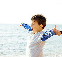 Image showing little cute boy on sea coast thumbs up