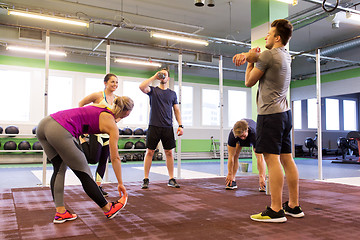 Image showing group of happy friends stretching in gym