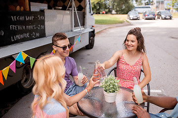 Image showing friends clinking bottles with drinks at food truck