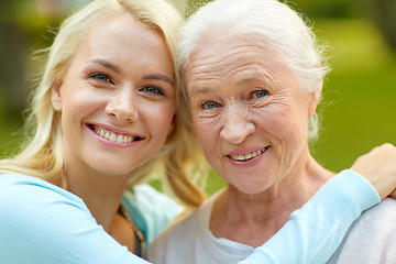 Image showing daughter with senior mother hugging on park bench