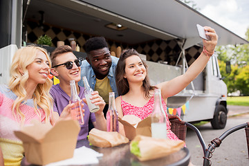 Image showing happy young friends taking selfie at food truck