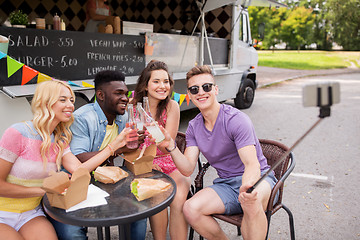 Image showing happy young friends taking selfie at food truck