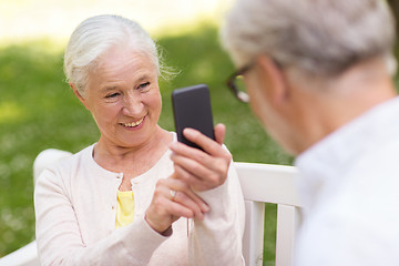 Image showing old woman photographing man by smartphone in park