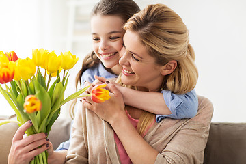 Image showing happy girl giving flowers to mother at home