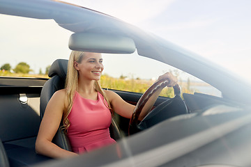 Image showing happy young woman driving convertible car