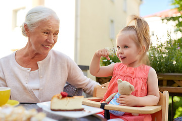 Image showing little girl with grandmother eating cafe