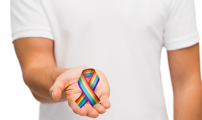 Image showing male hand holding gay pride awareness ribbon