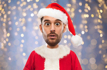 Image showing man in santa claus costume over christmas lights