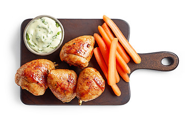 Image showing roasted chicken legs on wooden cutting board