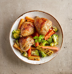 Image showing Plate of grilled chicken legs and vegetables