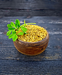 Image showing Fenugreek with leaf in clay bowl on wooden board