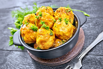 Image showing Meatballs in brazier with greens on black board