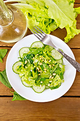 Image showing Salad from spinach and cucumber with napkin on board top