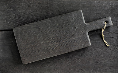 Image showing black cutting board on wooden table