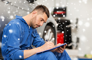 Image showing auto mechanic man with clipboard at car workshop