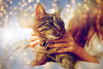 Image showing young woman with cat lying in bed at home