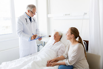 Image showing senior woman and doctor with clipboard at hospital