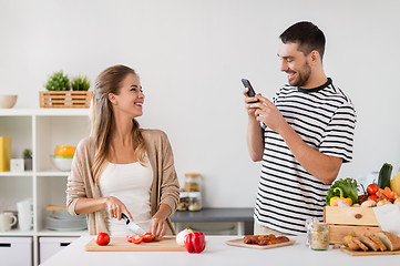 Image showing happy couple cooking food at home kitchen