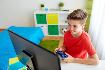 Image showing boy with gamepad playing video game on computer