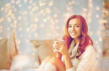 Image showing happy woman with cup of coffee in bed at home