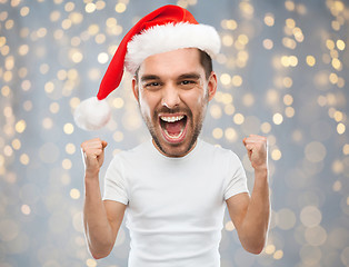 Image showing screaming man in santa hat over lights