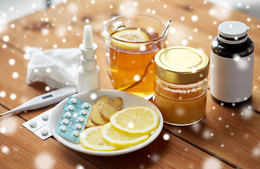 Image showing drugs, thermometer, honey and cup of tea on wood