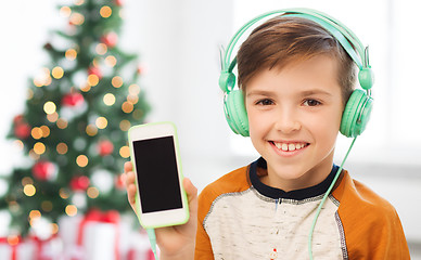 Image showing boy with smartphone and headphones at christmas