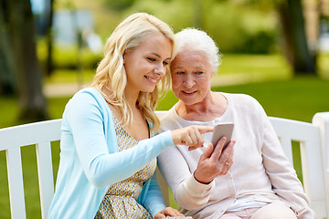 Image showing daughter and senior mother with smartphone at park