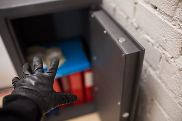 Image showing thief stealing valuables from safe at crime scene