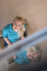 Image showing Young woman using laptop at home top view