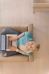 Image showing Young woman using laptop at home top view