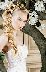 Image showing beauty young bride alone in luxury vintage interior with a lot of flowers close up, bridal style